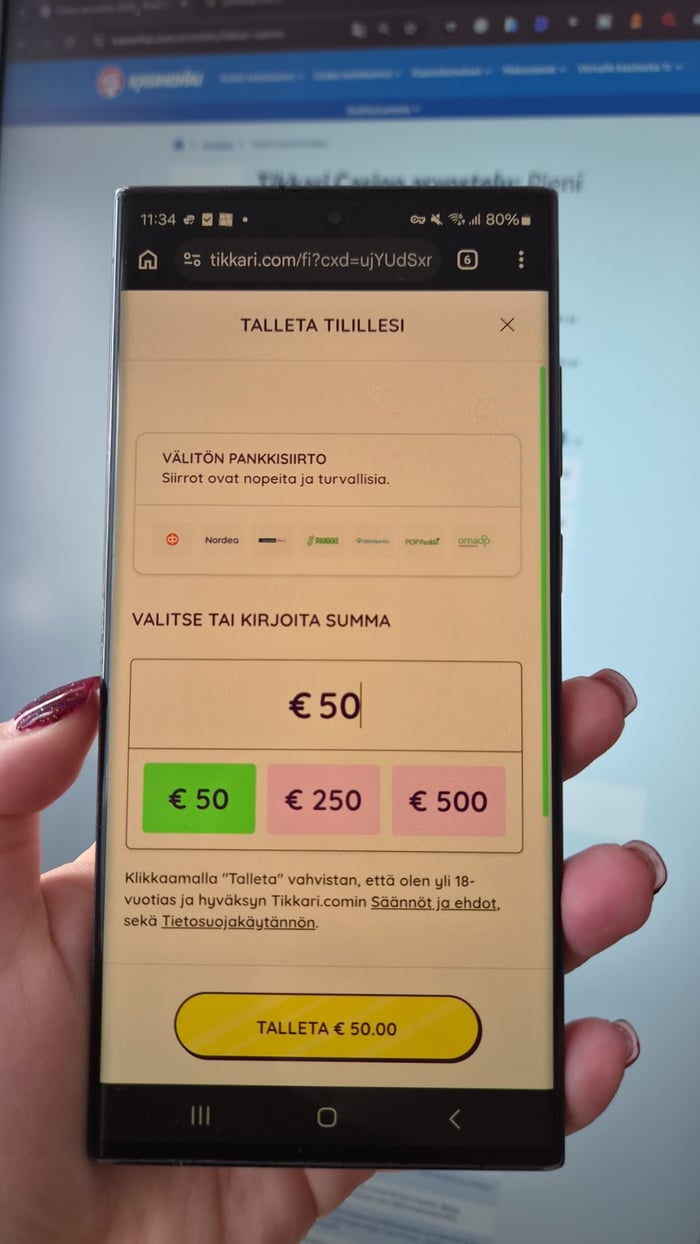 Käsi pitelee puhelinta, jonka näytöllä on Tikkari kasinon talletussivu ja valittuna 50 euron talletussumma.